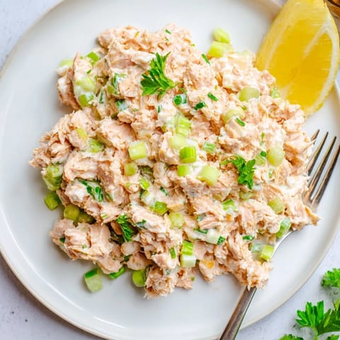 A close-up view of Spicy Zesty Tuna Salad showing flaky tuna mixed with creamy, bright orange spicy mayo.