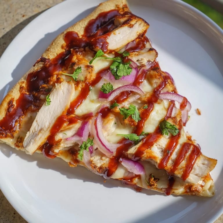 Freshly baked Chicken BBQ Pizza: a close-up shows the drizzles of extra barbecue sauce.