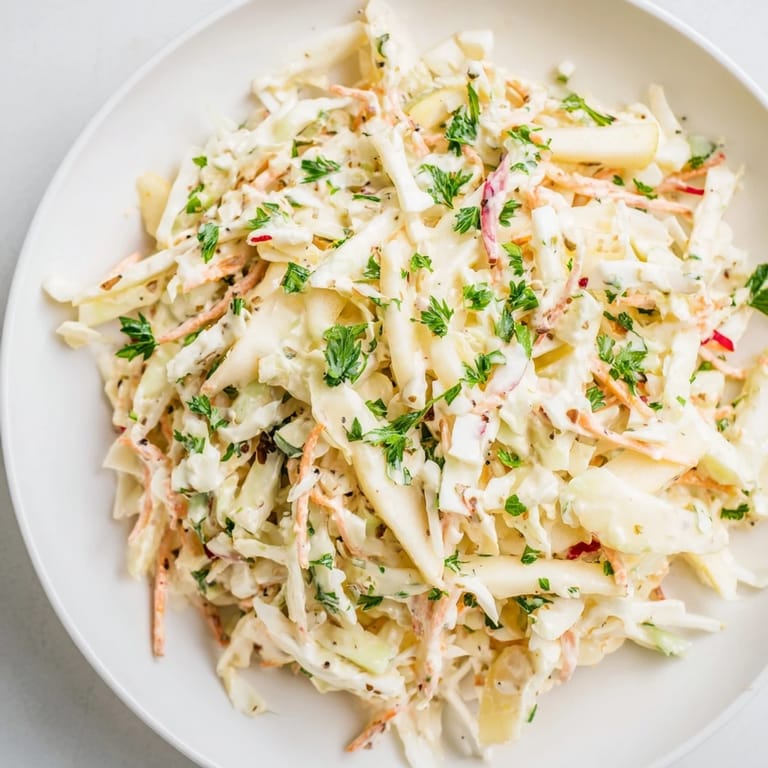 Freshly tossed Coleslaw with Apple, featuring crisp cabbage and sweet, shredded apple pieces.