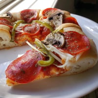 Golden, bubbling Stuffed Crust Pizza with melted cheese, pepperoni, and fresh peppers ready to eat.